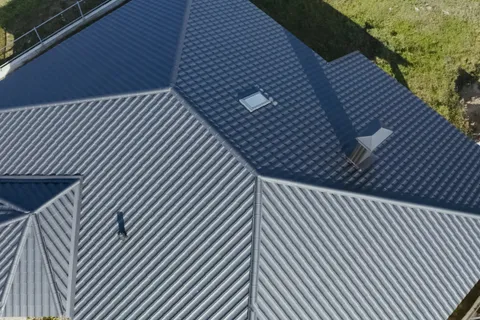 An aerial view of a tiled roof showing roof vents and ridge detail