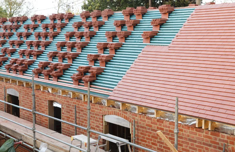 A new roof covering being fitted, with underlay and battens exposed